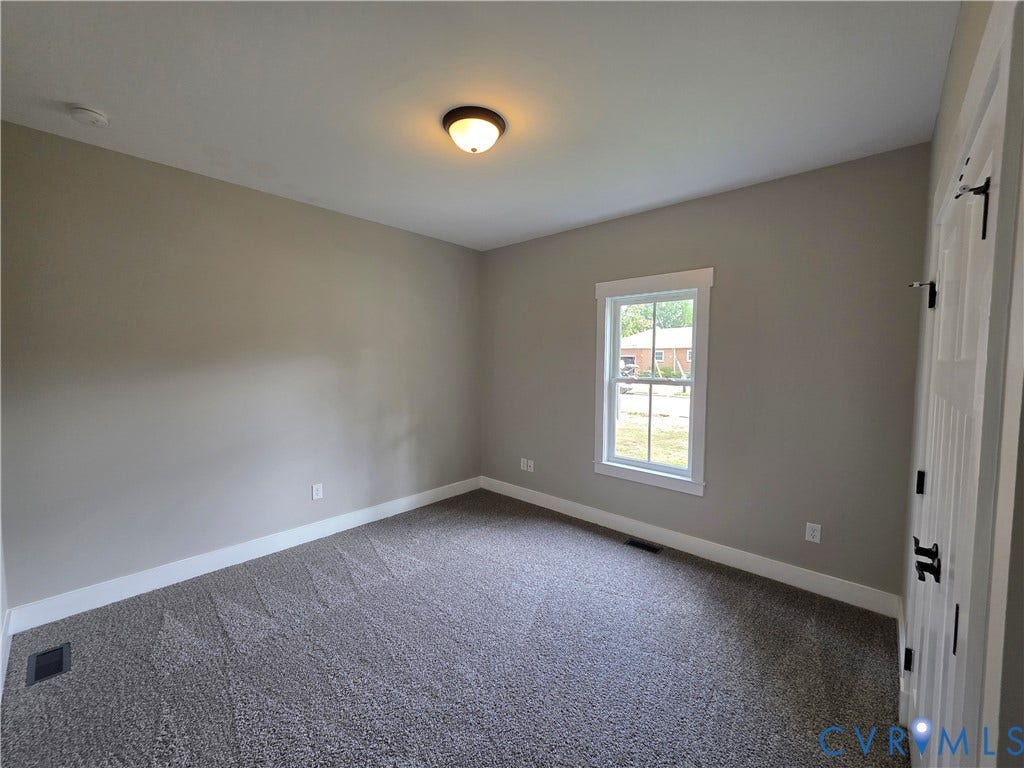3005 Portsmouth Street, Hopewell, VA 23860 Neutral-toned interior room featuring wall-to-wall carpeting, a multi-pane window with white trim, and a ceiling-mounted flush light fixture