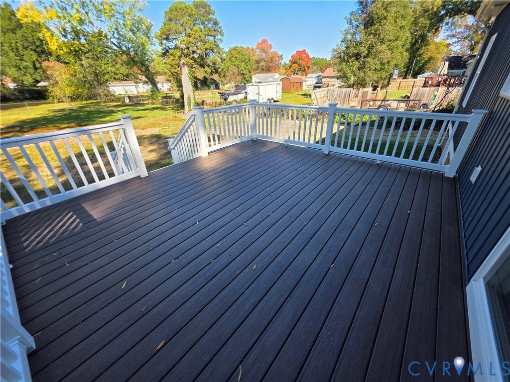 3005 Portsmouth Street, Hopewell, VA 23860 Elevated composite deck featuring white railings and staircase, dark-toned decking, and vertical exterior siding