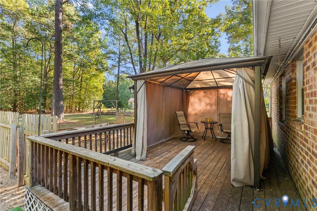 8444 New London Road, Mechanicsville, VA 23116 Outdoor wood deck featuring a covered gazebo structure, red brick exterior wall, and perimeter wood fencing