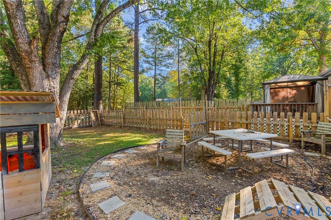 8444 New London Road, Mechanicsville, VA 23116 Private backyard featuring a wooden privacy fence, mature trees, an outdoor hardscape area, and a permanent gazebo structure
