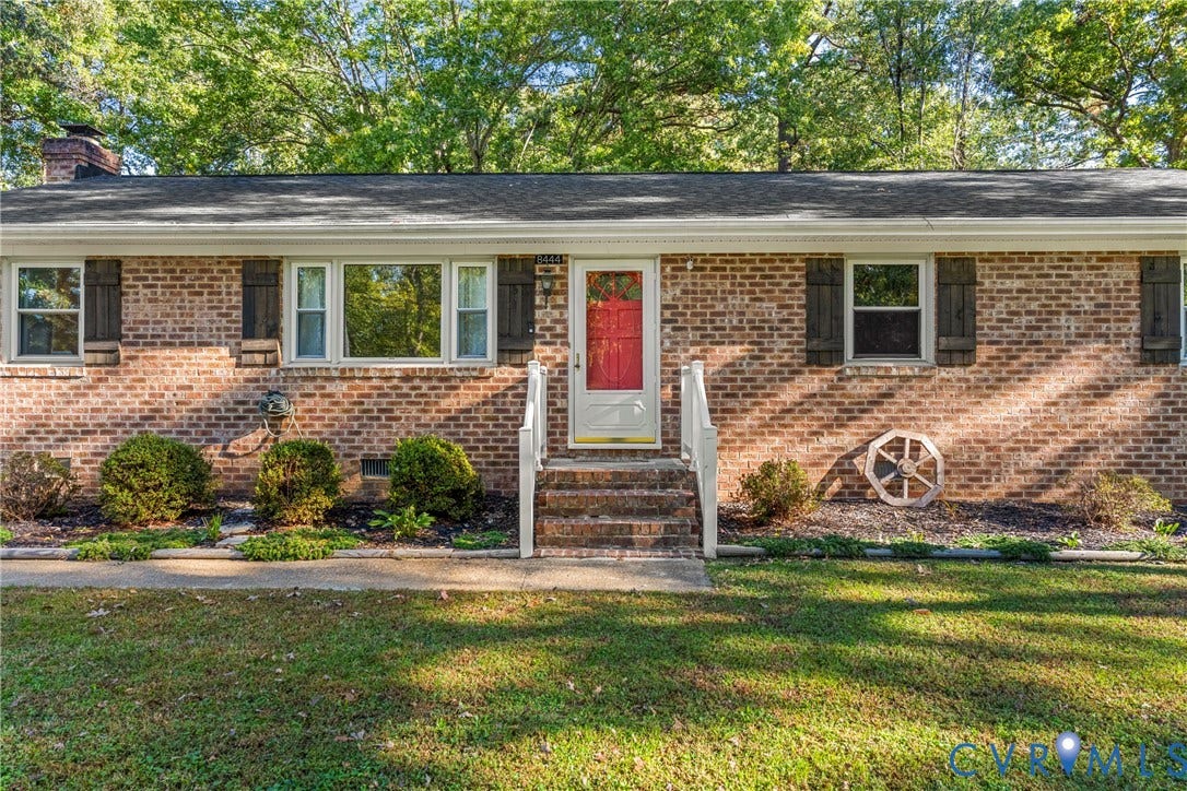 8444 New London Road, Mechanicsville, VA 23116 Brick exterior featuring decorative shutters, a covered entryway with white railings, and mature landscaping
