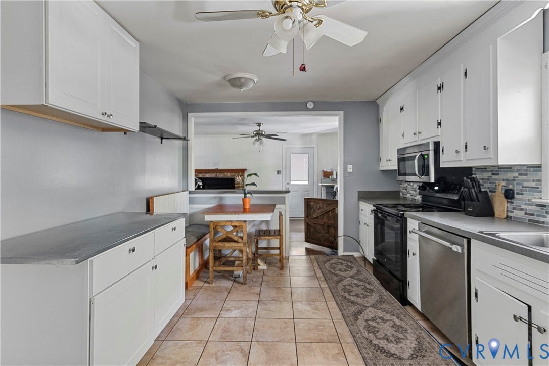 8444 New London Road, Mechanicsville, VA 23116 Kitchen featuring white cabinetry, multi-tone tile backsplash, tile flooring, built-in breakfast nook, and stainless steel appliances
