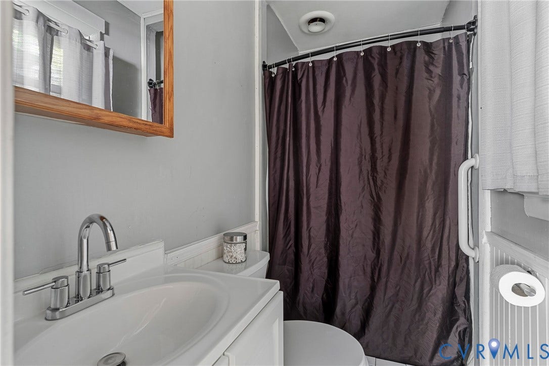 8444 New London Road, Mechanicsville, VA 23116 Bathroom featuring a vanity with an integrated basin, a polished chrome high-arc faucet, a wood-framed mirror, and a wall-mounted grab bar