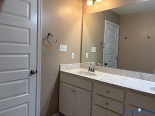 2144 Perennial Circle, Henrico, VA 23233 Double vanity with stone-surface countertop, integrated dual sinks, polished chrome fixtures, and a wall-to-wall mirror