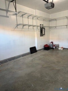 2144 Perennial Circle, Henrico, VA 23233 Garage interior featuring concrete flooring, white-painted walls, mounted wire shelving, and an integrated garage door opener