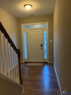 2144 Perennial Circle, Henrico, VA 23233 Entryway featuring a white panel door with sidelights and transom window, wood-finish flooring, and a staircase with a wooden handrail and white balusters
