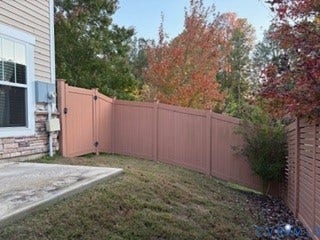 2144 Perennial Circle, Henrico, VA 23233 Backyard featuring a concrete patio, solid vinyl privacy fencing, and stone veneer foundation detailing