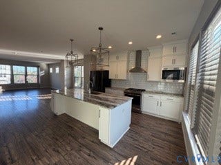 2144 Perennial Circle, Henrico, VA 23233 Kitchen featuring white shaker-style cabinetry, a stone-patterned island countertop, stainless steel appliances, a tiled backsplash, and wood-finish flooring