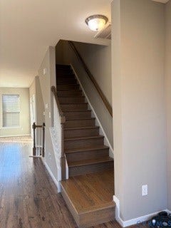 2144 Perennial Circle, Henrico, VA 23233 Staircase featuring wood-finish treads, a painted white balustrade with a stained wood handrail, and wood-finish flooring
