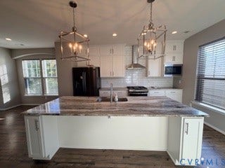 2144 Perennial Circle, Henrico, VA 23233 Kitchen featuring a large central island with a stone countertop, white cabinetry, a white subway tile backsplash, stainless steel range hood, and dual lantern-style pendant lights