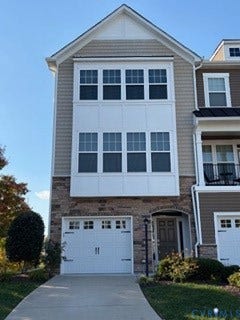 2144 Perennial Circle, Henrico, VA 23233 Multi-story exterior featuring stone veneer siding, horizontal siding, a bay window with grid-pane glass, and an attached single-car garage with hardware accents