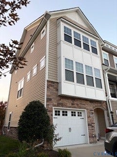 2144 Perennial Circle, Henrico, VA 23233 Multi-level exterior featuring light-toned horizontal siding, a multi-paneled stone veneer facade, a multi-pane bay window, and an attached two-car garage with a decorative window pane design
