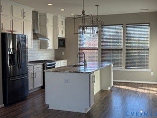 2144 Perennial Circle, Henrico, VA 23233 Kitchen featuring wood-finish flooring, white cabinetry, a center island with stone-surface countertop, stainless steel appliances, and dual metal-frame pendant lighting
