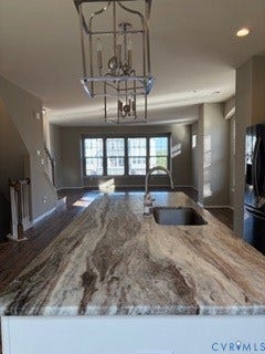 2144 Perennial Circle, Henrico, VA 23233 Kitchen island featuring a stone countertop, undermount sink, gooseneck faucet, metal geometric pendant lighting, and white cabinetry