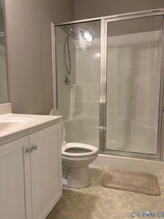 2144 Perennial Circle, Henrico, VA 23233 Bathroom featuring a white vanity cabinet with an integrated sink, polished chrome hardware, a walk-in shower with a glass enclosure, and a handheld showerhead fixture