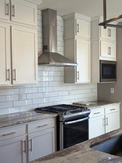 2144 Perennial Circle, Henrico, VA 23233 Kitchen featuring white shaker-style cabinetry, stone-patterned countertops, subway tile backsplash, stainless steel range hood, and built-in microwave