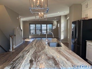 2144 Perennial Circle, Henrico, VA 23233 Kitchen island featuring a natural stone countertop, undermount sink with a gooseneck faucet, pendant lighting, wood-finish flooring, and white shaker-style cabinetry