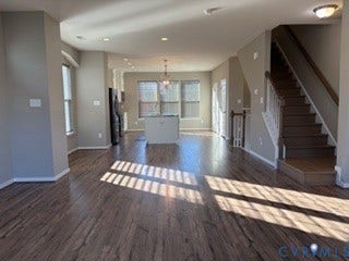 2144 Perennial Circle, Henrico, VA 23233 Open-concept interior featuring wood-finish flooring, recessed lighting, a central kitchen island, and a staircase with a white balustrade and wooden handrail