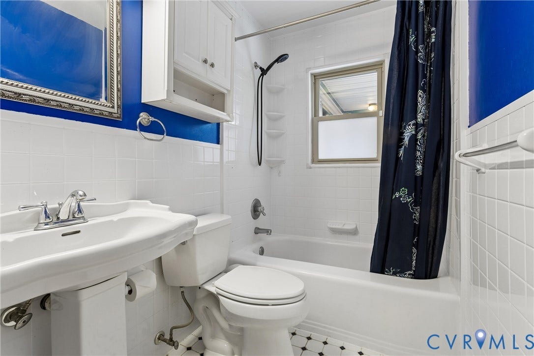 627 Sedgefield Drive, 992- All Others Area 107, Newport News, VA 23605 Pedestal sink with polished chrome faucet, white wall-mounted storage cabinet, white subway-style wall tile, built-in tub and shower combination, and geometric tile flooring