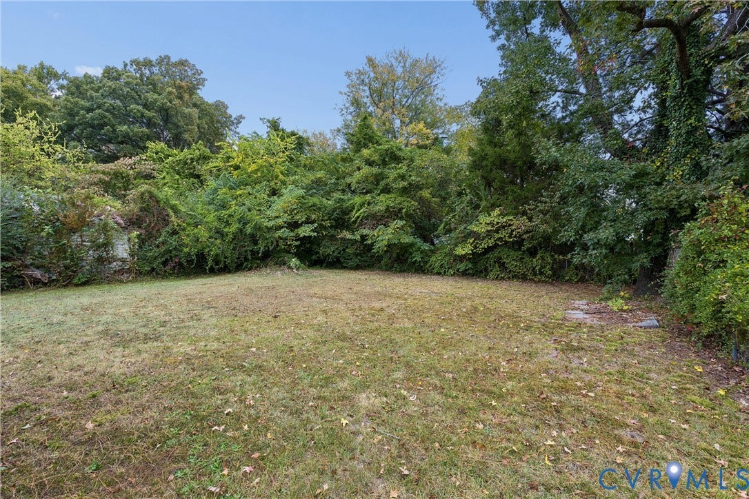 627 Sedgefield Drive, 992- All Others Area 107, Newport News, VA 23605 Expansive backyard featuring an open grass lawn, mature trees, and dense natural perimeter vegetation