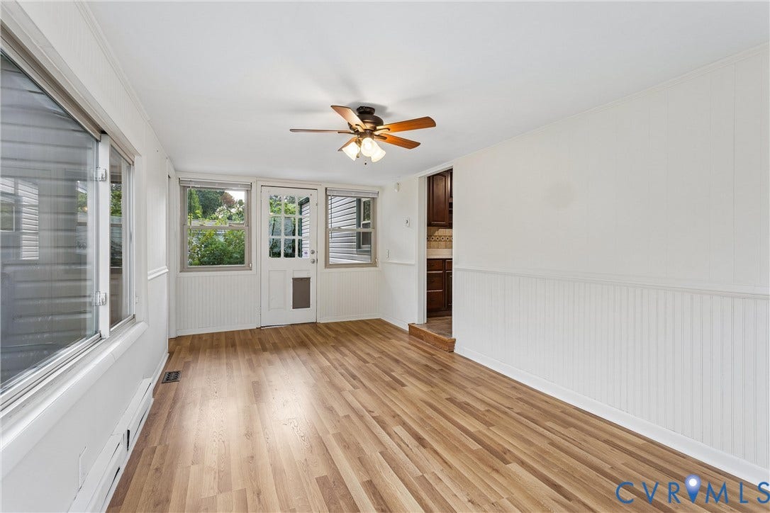627 Sedgefield Drive, 992- All Others Area 107, Newport News, VA 23605 Wood-finish flooring, white beadboard wainscoting, multiple windows, and a multi-light exterior door with a ceiling fan