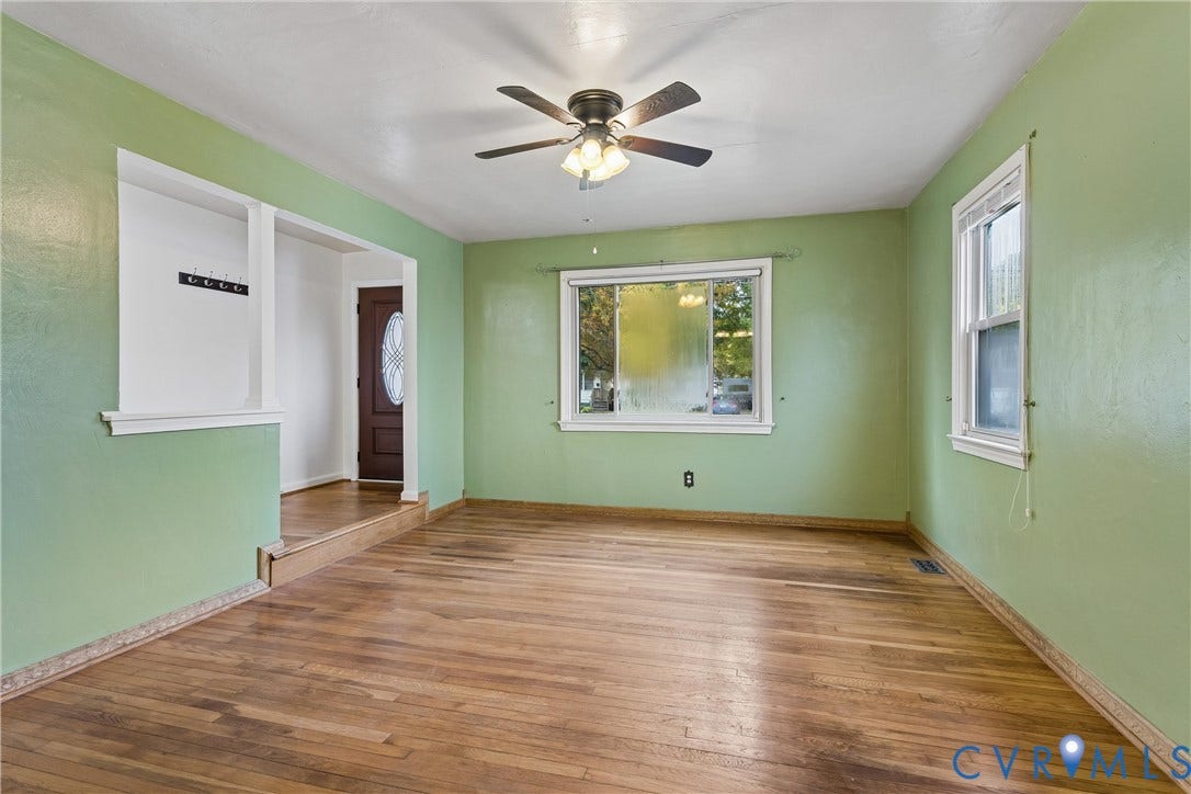 627 Sedgefield Drive, 992- All Others Area 107, Newport News, VA 23605 Living area featuring wood-finish flooring, a ceiling fan with integrated light fixture, multiple double-hung windows, and a built-in wall niche
