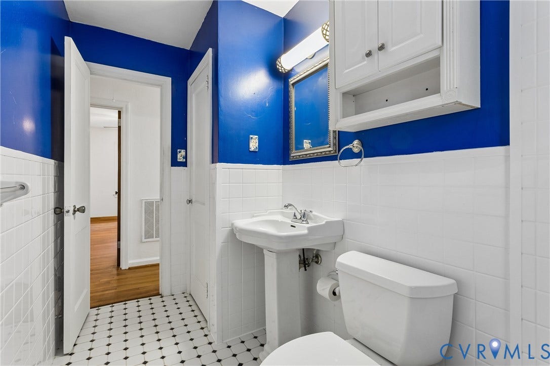 627 Sedgefield Drive, 992- All Others Area 107, Newport News, VA 23605 White ceramic wall tile, black and white mosaic floor tile, pedestal sink, wall-mounted cabinet, and integrated lighting fixture