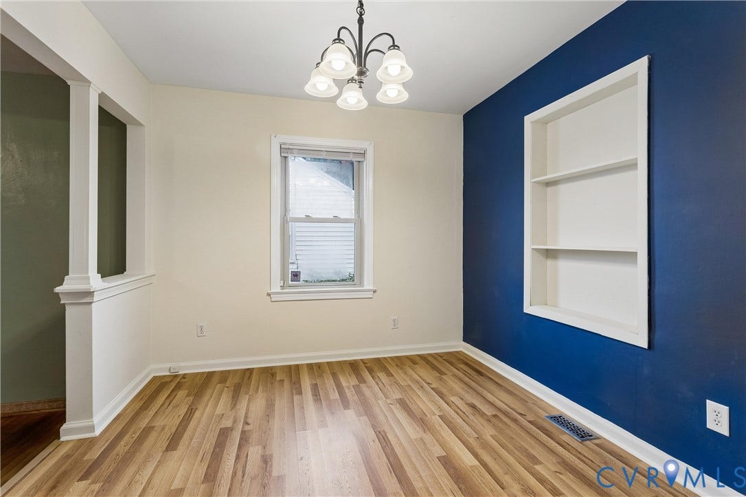 627 Sedgefield Drive, 992- All Others Area 107, Newport News, VA 23605 Room featuring wood-finish flooring, a built-in recessed wall shelving unit, a five-light chandelier, and a partial wall divider with a column