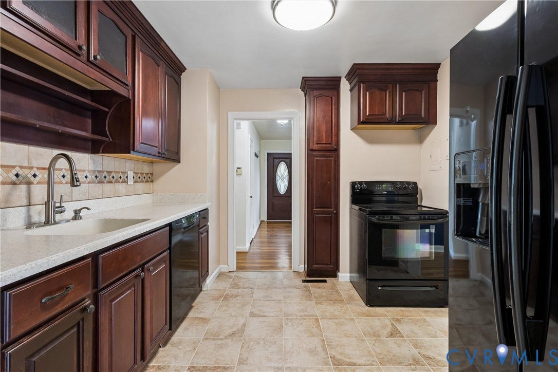 627 Sedgefield Drive, 992- All Others Area 107, Newport News, VA 23605 Kitchen featuring dark-toned cabinetry, solid surface countertops, tile backsplash with decorative inlay, built-in floor-to-ceiling pantry storage, and black appliance suite