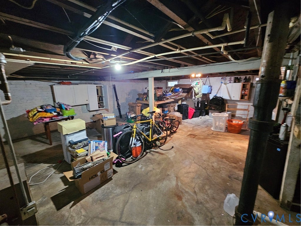 1206 Westminster Avenue, Richmond, VA 23227 Unfinished lower level featuring concrete flooring, exposed ceiling joists, painted masonry walls, and built-in wall cabinetry