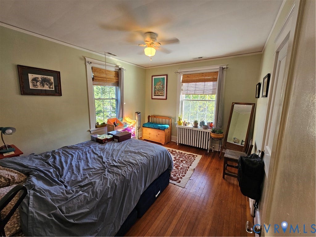 1206 Westminster Avenue, Richmond, VA 23227 Wood-finish flooring, two sash windows with natural light, a ceiling-mounted light fixture, and a metal radiator