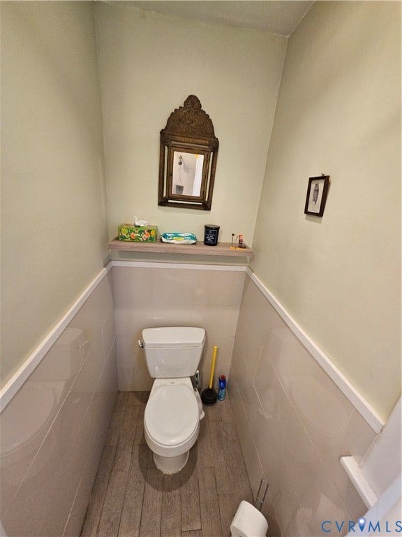 1206 Westminster Avenue, Richmond, VA 23227 Half-bath featuring wood-finish flooring, ceramic tile wainscoting, and a built-in wall shelf