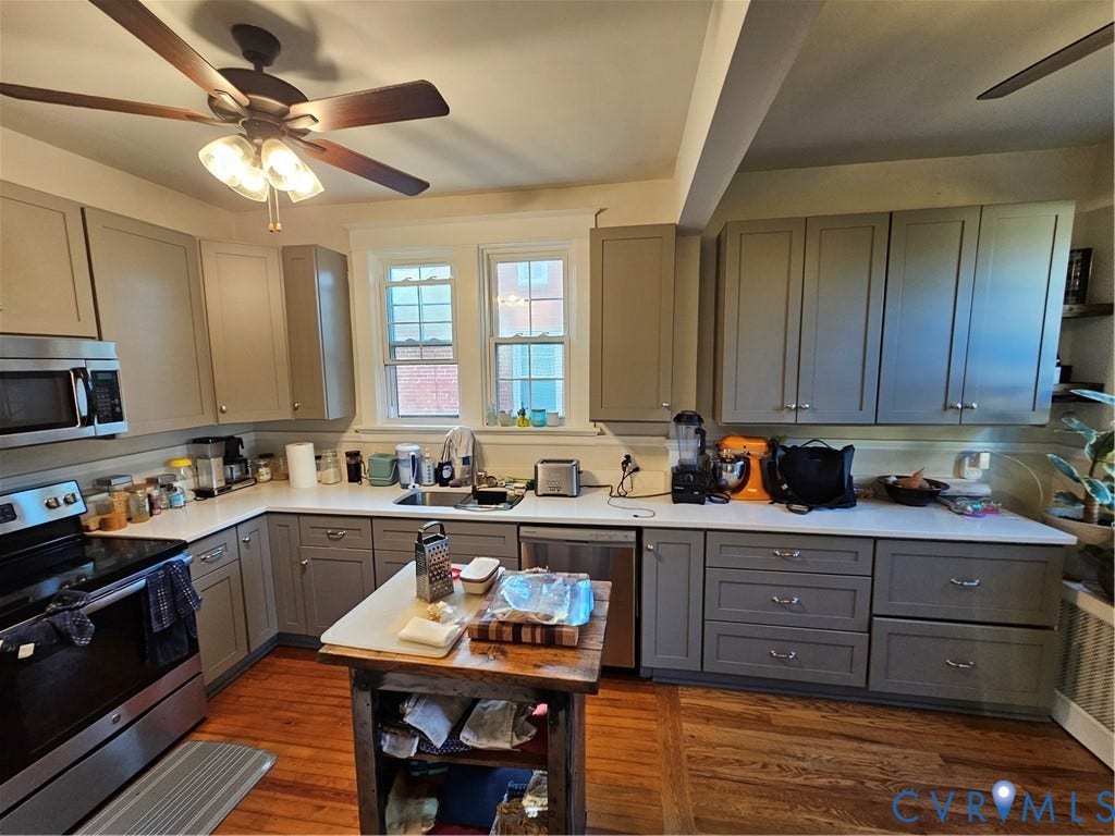 1206 Westminster Avenue, Richmond, VA 23227 Kitchen featuring shaker-style cabinetry, solid-surface countertops, stainless steel appliances, wood flooring, and a ceiling fan with integrated lighting