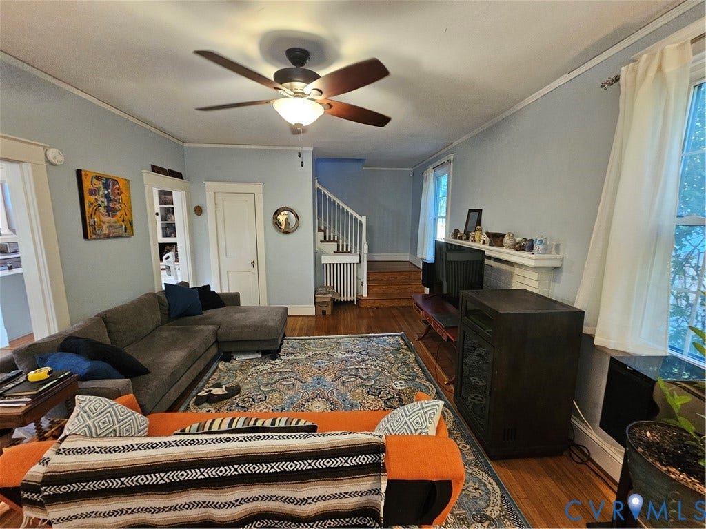 1206 Westminster Avenue, Richmond, VA 23227 Living area featuring wood-finish flooring, a ceiling fan with integrated lighting, a fireplace mantle, and staircase with white millwork railings