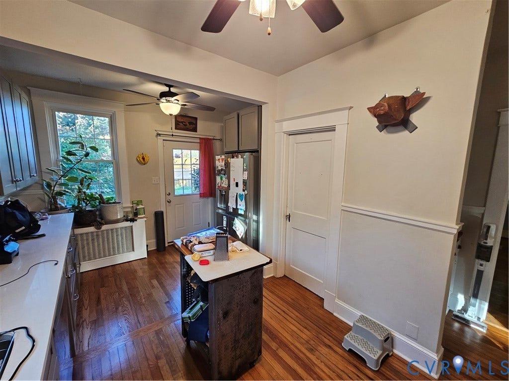 1206 Westminster Avenue, Richmond, VA 23227 Kitchen area featuring wood-finish flooring, white solid-surface countertops, wainscoting, dual ceiling fans, and a glass-paneled exterior door