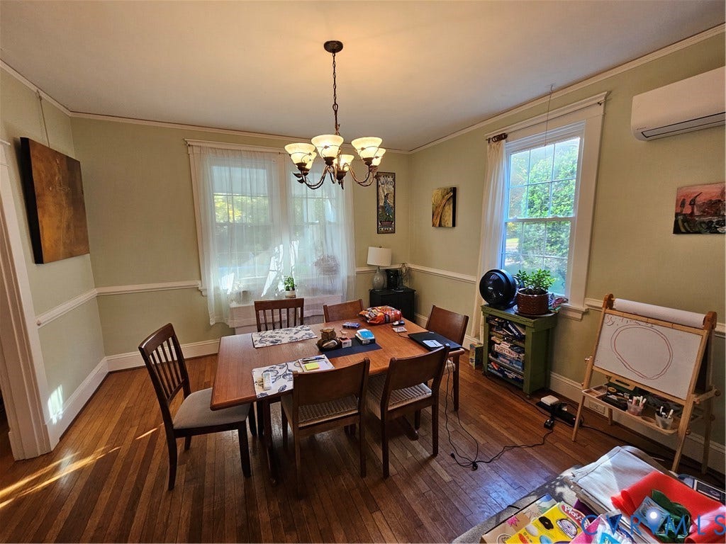 1206 Westminster Avenue, Richmond, VA 23227 Dining area featuring wood-finish flooring, crown molding, chair rail trim, a multi-arm chandelier, and a wall-mounted mini-split system