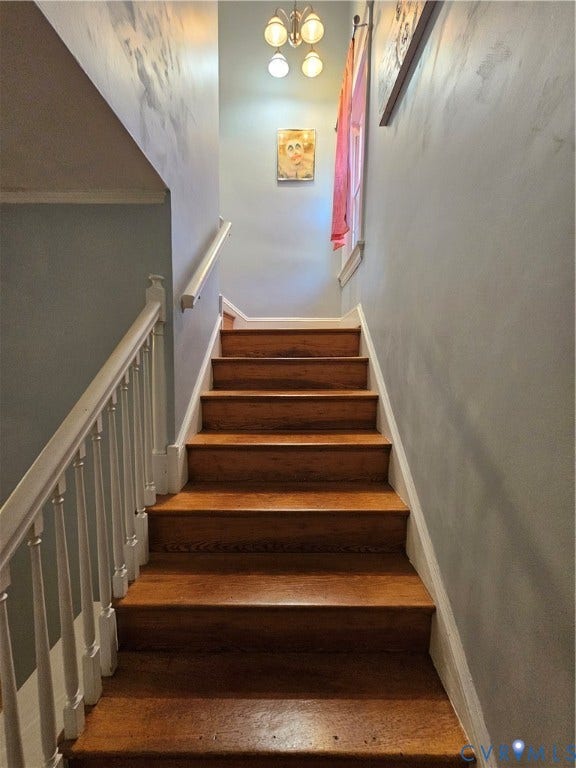 1206 Westminster Avenue, Richmond, VA 23227 Staircase featuring wood-finish treads, white painted spindles, a matching handrail, and a four-light fixture