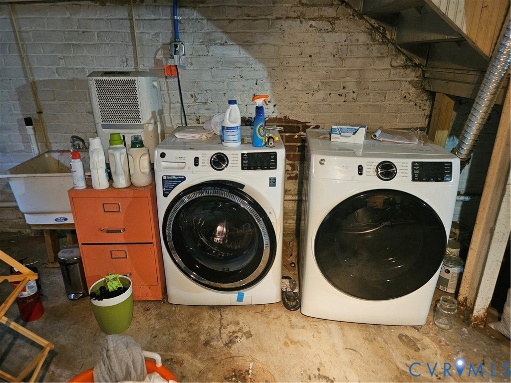 1206 Westminster Avenue, Richmond, VA 23227 Laundry area featuring a front-load washer and dryer set, white utility sink, and painted brick masonry walls