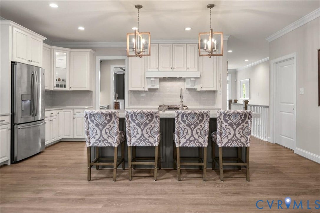 12168 Readers Pointe Drive, Readers Branch, Goochland, VA 23103 Kitchen featuring shaker-style cabinetry, stainless steel refrigerator, stone-surface central island, and wood-finish flooring, accented by geometric pendant lighting