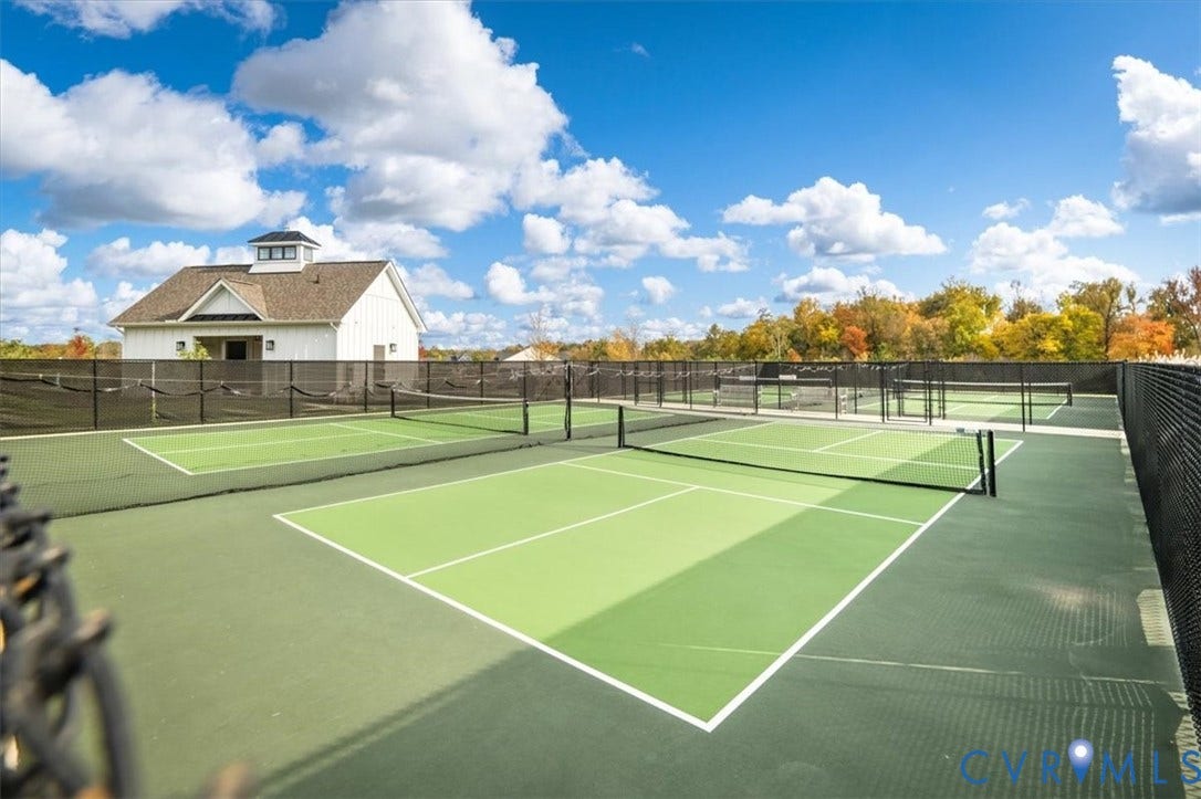 12168 Readers Pointe Drive, Readers Branch, Goochland, VA 23103 Multiple outdoor courts featuring synthetic surface material and black chain-link fencing, accompanied by a detached structure with a cupola and white siding