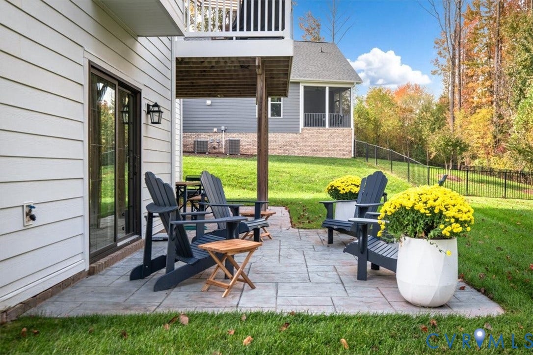 12168 Readers Pointe Drive, Readers Branch, Goochland, VA 23103 Terrace Level Stamped concrete patio featuring horizontal lap siding, a covered upper-level deck, and a black metal perimeter fence