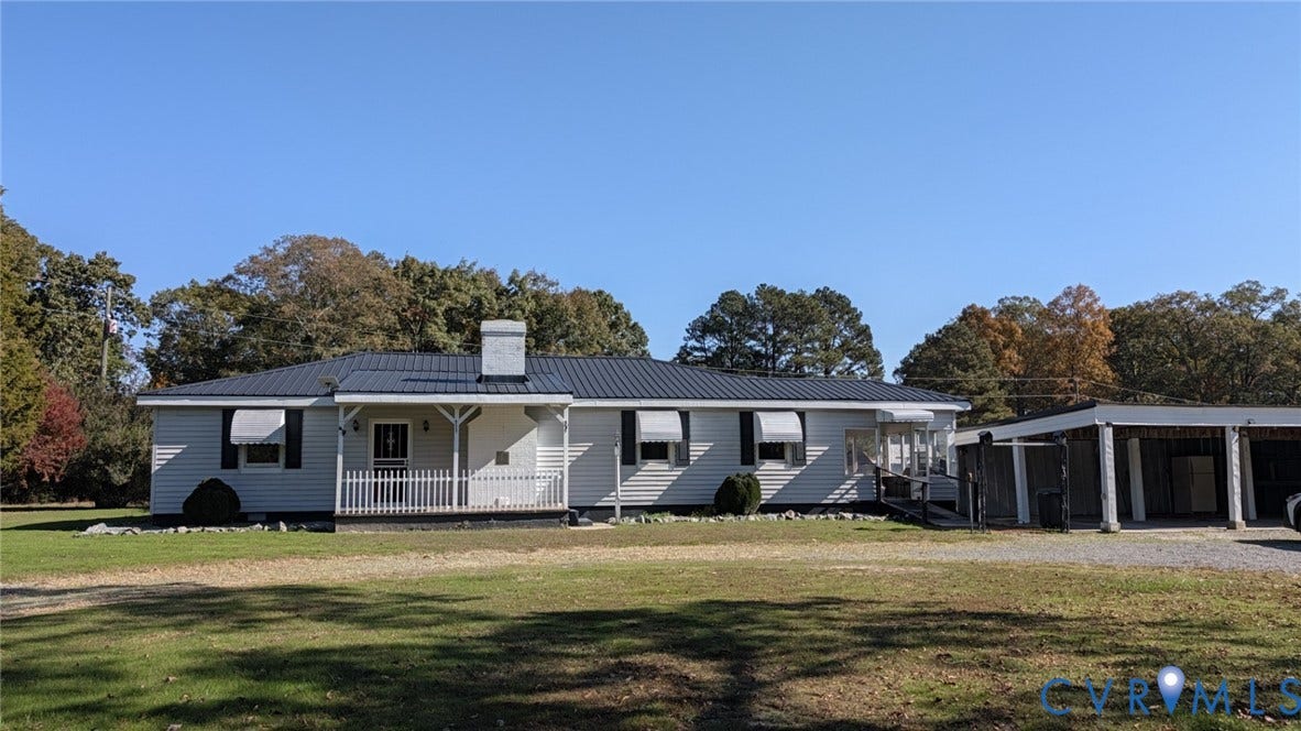 8893 King William Road, King William, VA 23009 Single-story exterior featuring a metal roof, white siding, a covered front porch with railing, exterior shutters, and an attached carport