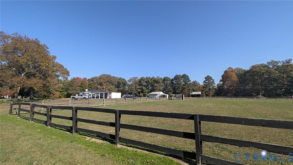 8893 King William Road, King William, VA 23009 Expansive open pasture featuring post-and-rail fencing, multiple outbuildings, and mature tree growth