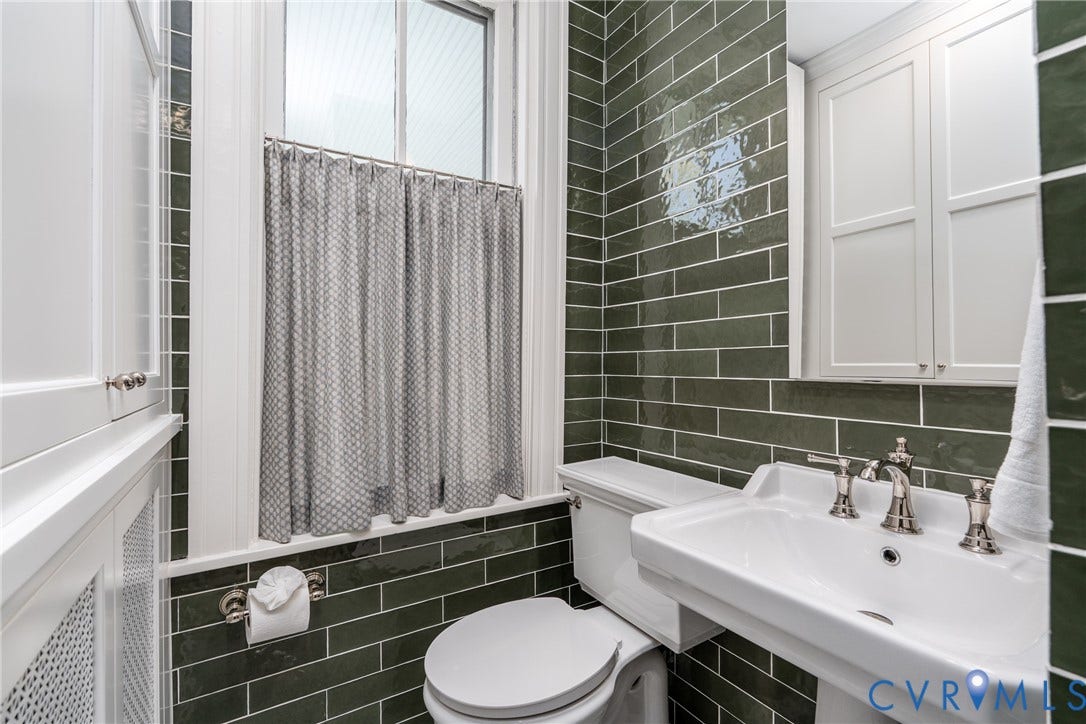 106 N Shields Avenue, The Fan, Richmond, VA 23220 Custom built-in storage cabinet beside the pedestal sink.