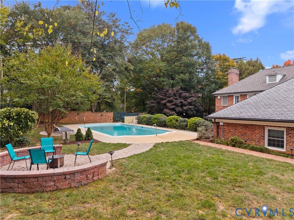 1203 Rothesay Circle, Windsor Farms, Richmond, VA 23221 Backyard featuring a swimming pool with concrete decking, a circular paver fire pit area, a brick retaining wall, and mature landscaping