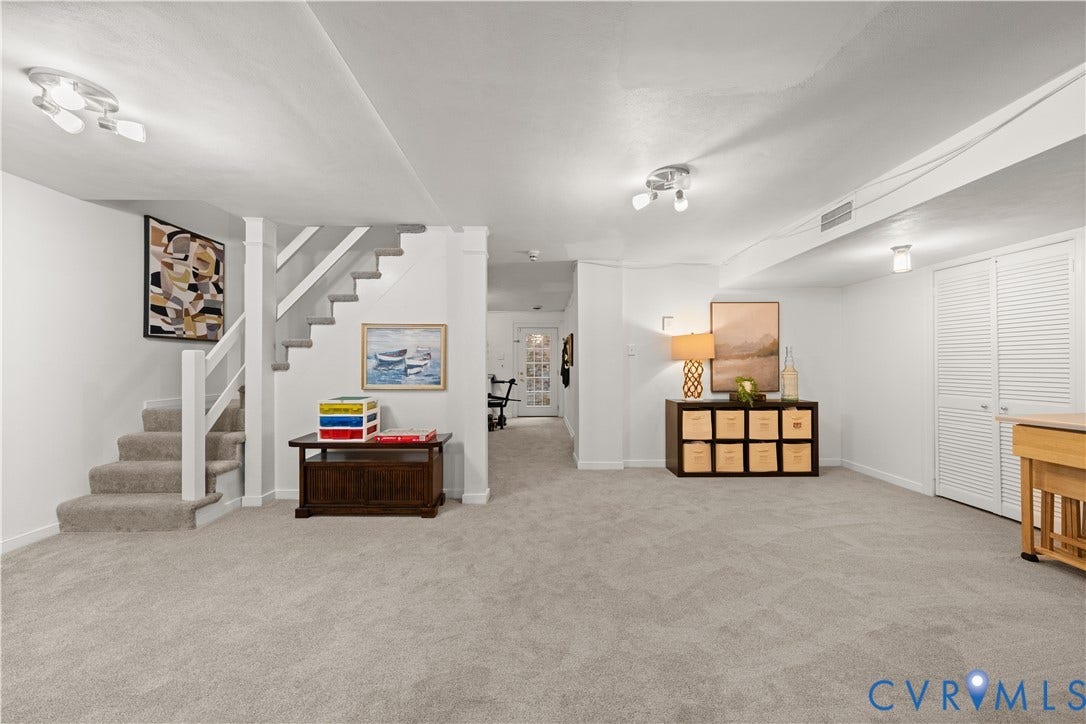 1203 Rothesay Circle, Windsor Farms, Richmond, VA 23221 Open-concept interior space featuring wall-to-wall carpeting, staircase with wooden handrail, multi-light ceiling fixtures, and louvered double-door storage closet