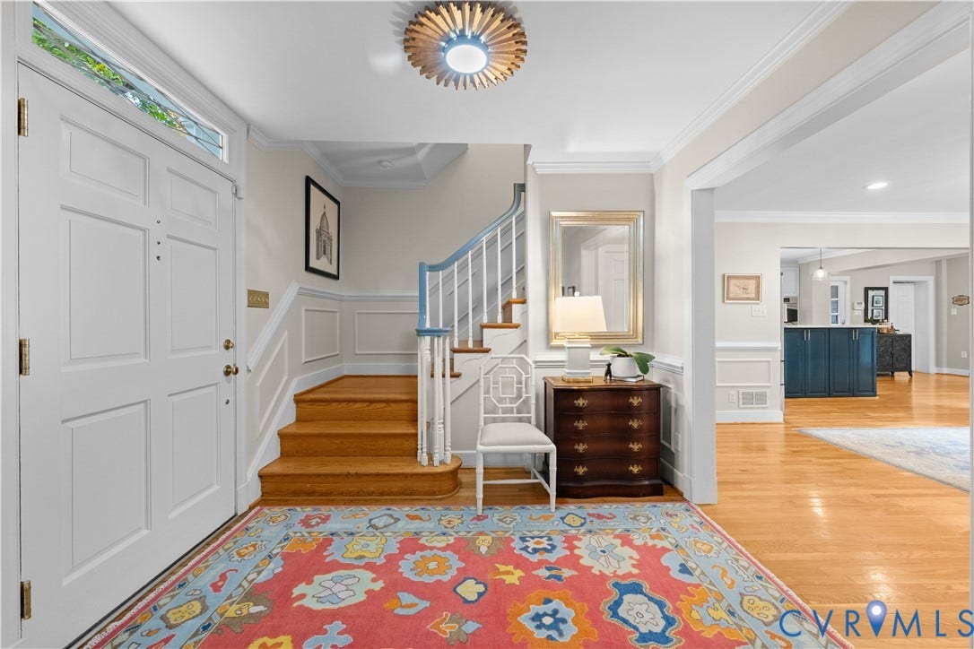 1203 Rothesay Circle, Windsor Farms, Richmond, VA 23221 Entryway featuring a white paneled front door with transom window, wood-finish flooring, staircase with a white balustrade, wall wainscoting, and a decorative overhead light fixture