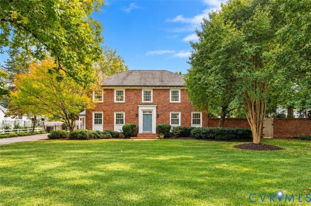 1203 Rothesay Circle, Windsor Farms, Richmond, VA 23221 Two-story brick exterior featuring a multi-pane window configuration, a central entryway with transom light, a pitched roof, and a perimeter brick privacy wall