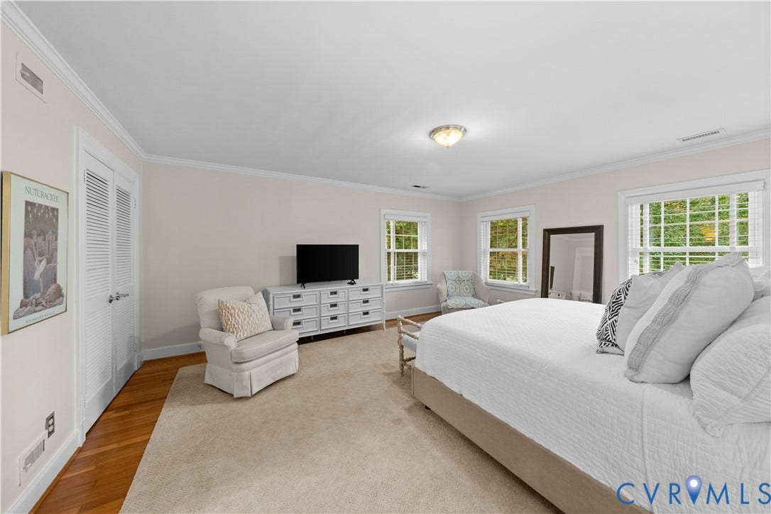 1203 Rothesay Circle, Windsor Farms, Richmond, VA 23221 Spacious room featuring neutral carpeting, hardwood-finish flooring along the perimeter, white louvered-door closet, multi-pane windows with grids, and crown molding
