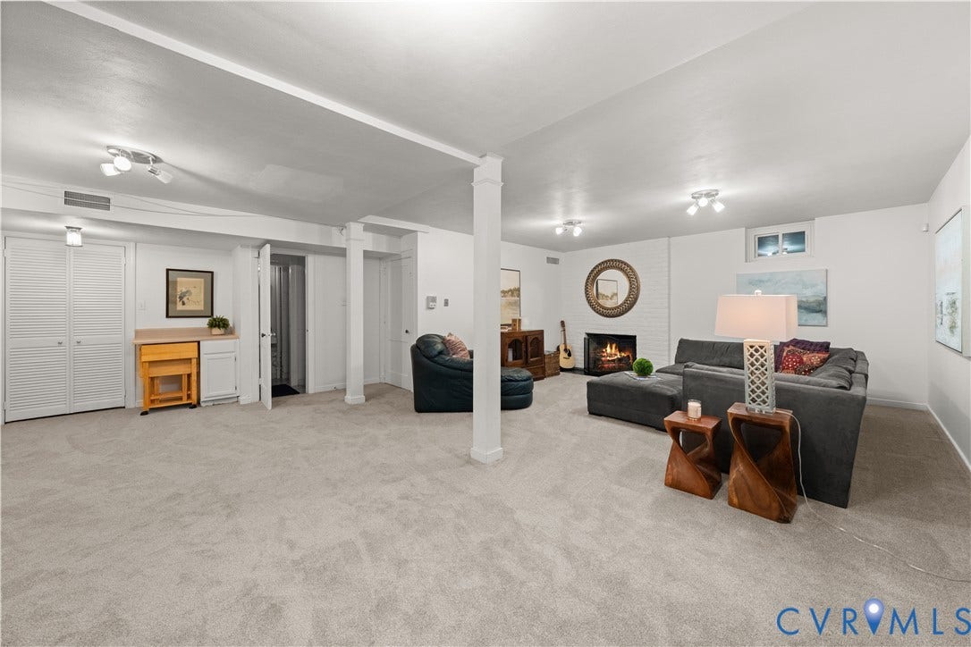 1203 Rothesay Circle, Windsor Farms, Richmond, VA 23221 Spacious interior featuring neutral carpeting, a painted brick fireplace, built-in cabinetry, dual structural support columns, and recessed lighting